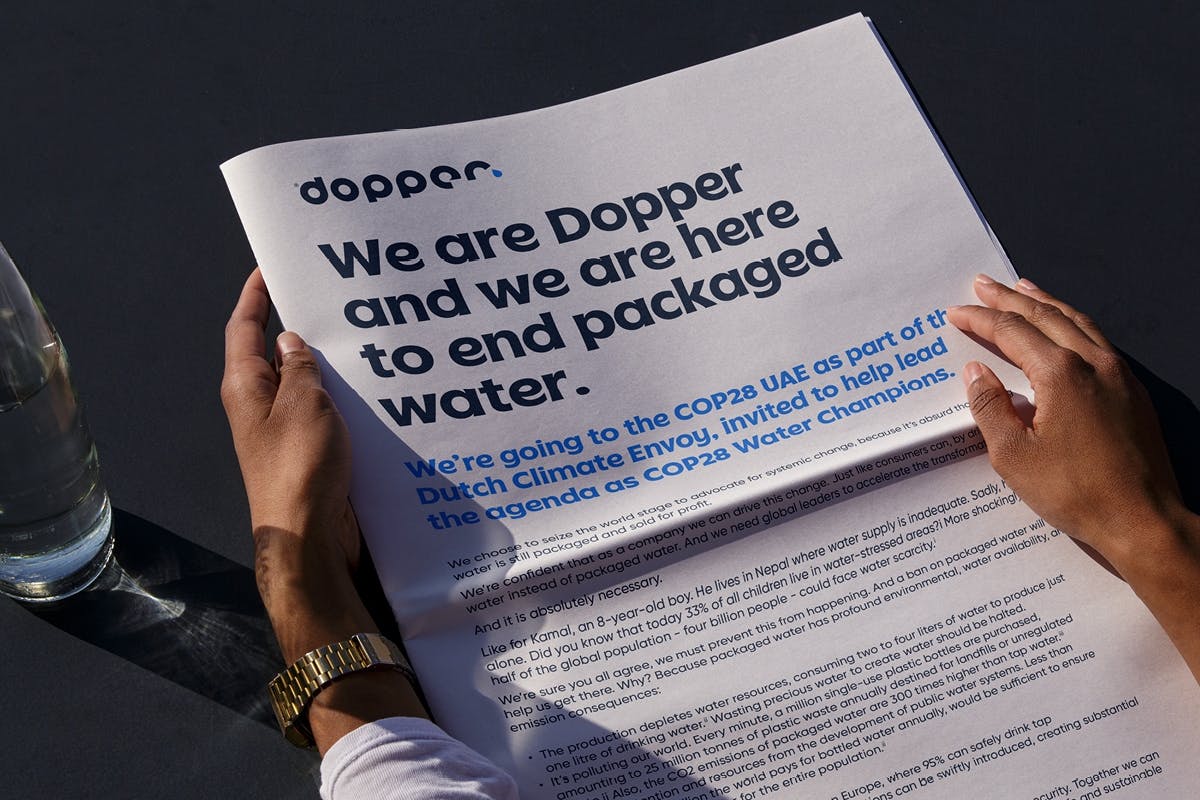 Person holding paper from Dopper about ending packaged water